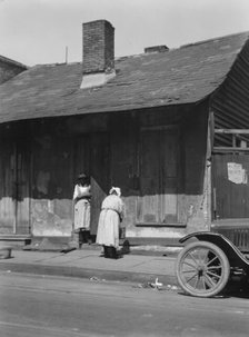Two women standing in or by a doorway, New Orleans, between 1920 and 1926. Creator: Arnold Genthe.