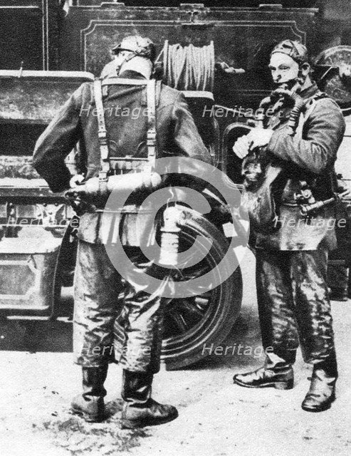 Firefighters donning smoke helmets, Farringdon Street rubber works, London, 1926-1927. Artist: Unknown