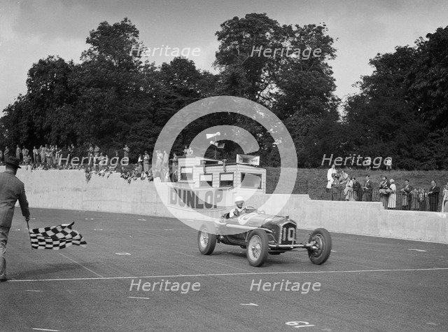 Alfa Romeo of Kenneth Evans taking the chequered flag at Crystal Palace, 1939. Artist: Bill Brunell.