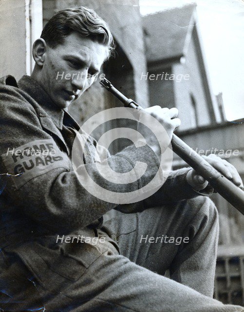 British Home Guard soldier cleaning his rifle, World War II, c1940-c1944. Artist: Unknown