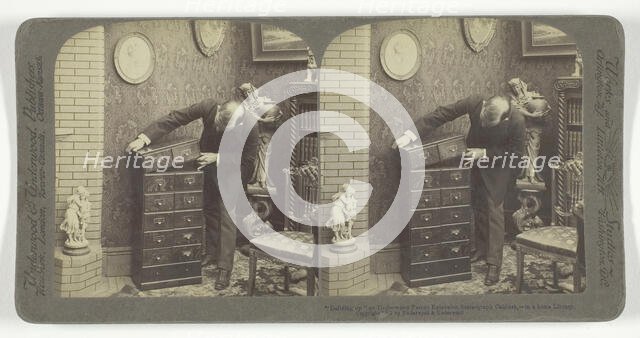 Building up an Underwood Patent Extension Stereograph Cabinet, - in a home Library, 1901. Creator: Underwood & Underwood.