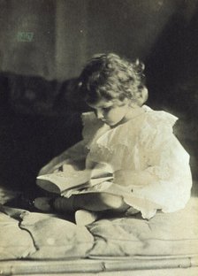 Girl sitting with legs folded, reading a book, c1900. Creator: Eva Watson-Schutze.