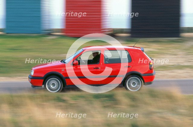 Man driving 1996 Vokswagen Golf Gti. Artist: Unknown.