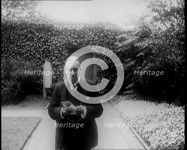 Prime Minister of Britain, Stanley Baldwin, Walking in the Gardens at Chequers Whilst Reading, 1926. Creator: British Pathe Ltd.