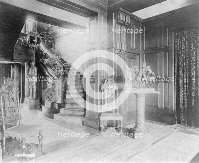 Hall and stairway, with suit of armor at left, and statue of cow..., Greenwich, Connecticut, 1908. Creator: Frances Benjamin Johnston.