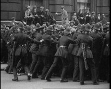 British Police Officers Holding Back Crowds of Demonstrators in Downing Street, London, 1920. Creator: British Pathe Ltd.