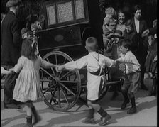 A Group of Civilian Children Dancing Around a Hurdy Gurdy, 1920. Creator: British Pathe Ltd.