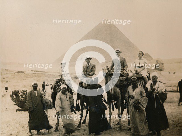 British tourists seated on camels in front of The Great Pyramid, Giza, Egypt, 1936. Artist: Unknown
