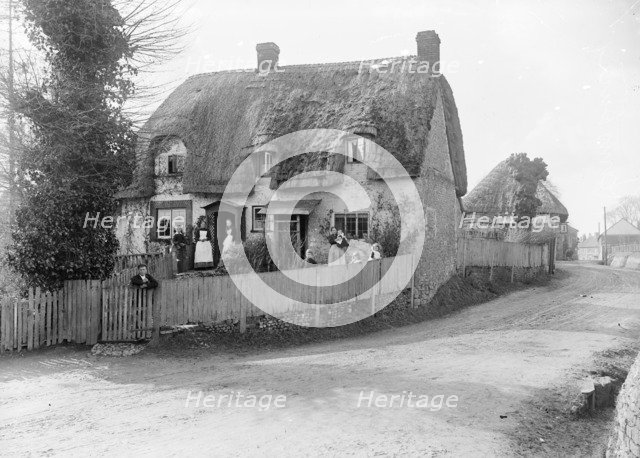 Thatched cottage with its inhabitants standing outside, Ramsbury, Wiltshire, c1860-c1922. Artist: Henry Taunt