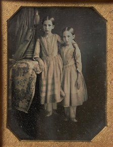 Two Identically Dressed Young Girls Standing Next to a Table, 1840s. Creator: Unknown.