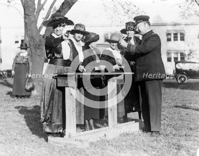 Police officer teaching women how to shoot, c. 1920.