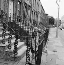 Woman sweeping front steps, London, 1960-1965. Artist: John Gay