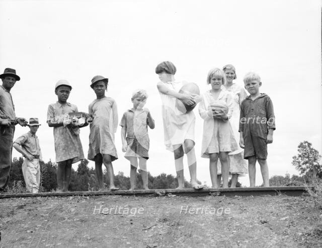 Sharecroppers' families gathering needs for their 4th of July celebration..., Mississippi, 1936. Creator: Dorothea Lange.