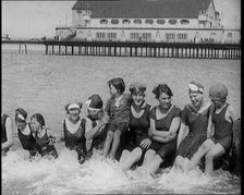 Women and Children Sitting on a Groyne, Splashing With Their Feet on a British Beach, 1920. Creator: British Pathe Ltd.