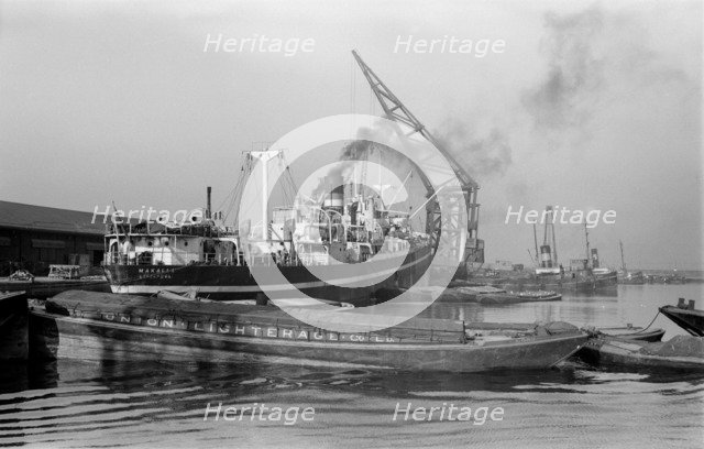A crane unloads cargo from the 'Makalla' in Tilbury Docks, Essex, c1945-c1965. Artist: SW Rawlings