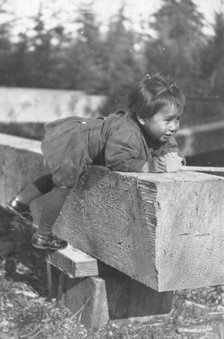 Eskimo child leaning on block of wood, 1905. Creator: Unknown.