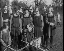 A Group of Young Female Civilians Wearing Gymslips Holding Lacrosse Sticks, 1920. Creator: British Pathe Ltd.