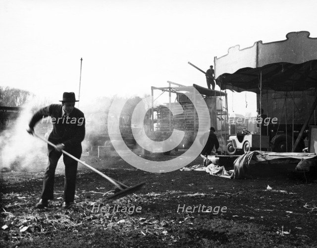 Cleaning up at Hampstead Funfair, April 1952. Artist: Henry Grant
