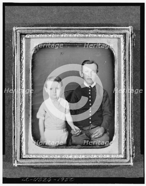 Unidentified boy seated in chair with child standing to left, three-quarter..., between 1850 & 1860. Creator: Unknown.