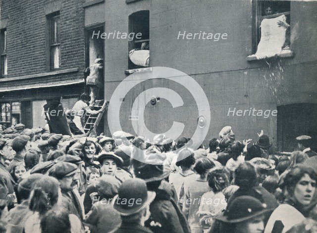 Crowd watching the looting of a German house in Poplar, c1914. Artist: Unknown