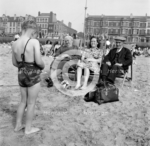 A child photographs his mother and grandparents on the beach, Blackpool, c1946-c1955. Artist: John Gay