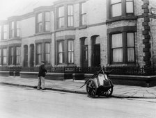 An 'Orderly Boy' and his cart sweeping a street, Liverpool, 1935. Artist: Unknown