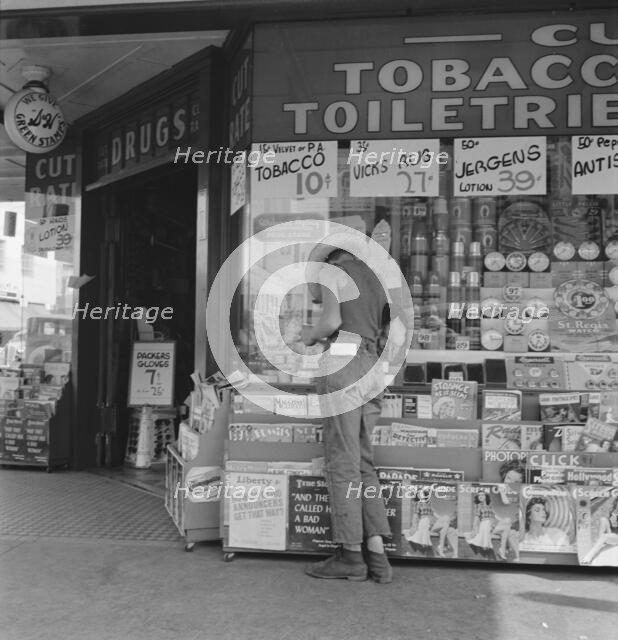 Half-grown farm boy on main drugstore corner in town, Medford, Oregon, 1939. Creator: Dorothea Lange.