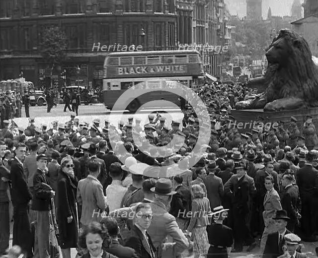 Crowds Watching a Military Band March in Trafalgar Square, 1940. Creator: British Pathe Ltd.