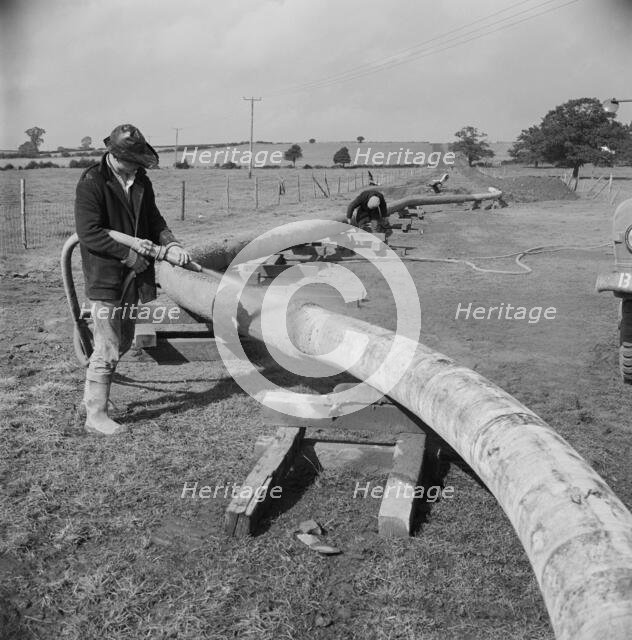 A worker carrying out guniting (spraying concrete) on the Mersey oil pipeline..., 24/09/1967. Creator: John Laing plc.