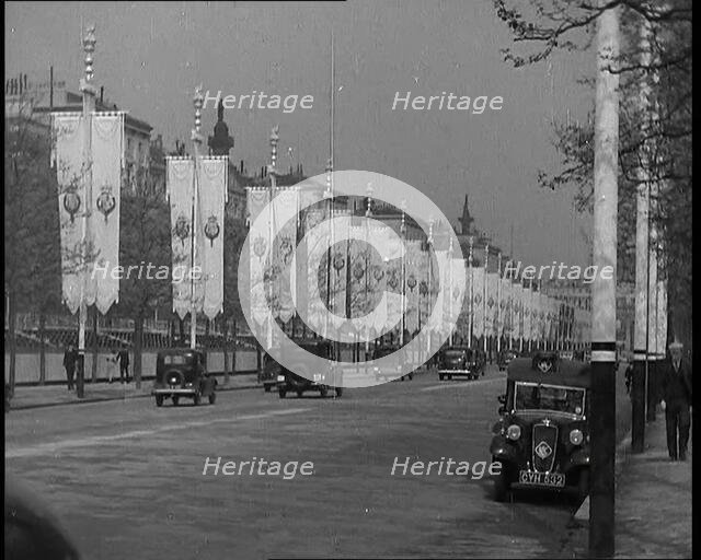 Cars Driving Down the Mall Which Is Decorated By Flags For the Coronation of King George VI, 1937. Creator: British Pathe Ltd.