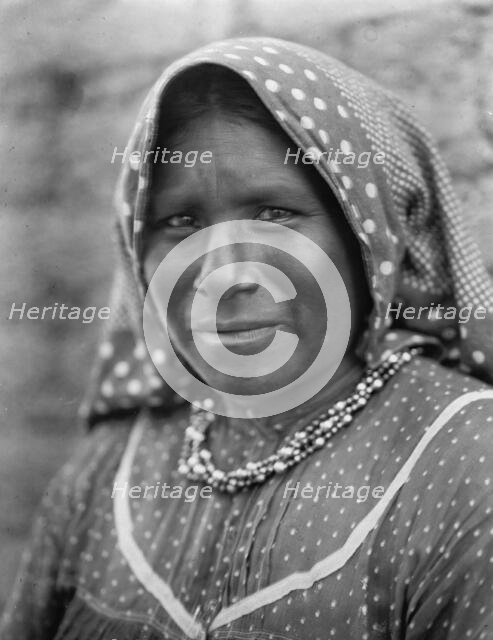 Yaqui matron, head-and-shoulders portrait, facing slightly left, wearing printed cotton..., c1907. Creator: Edward Sheriff Curtis.