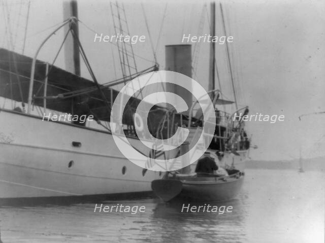 Man and woman in small boat alongside large boat or ship, Oyster Bay, Long Island, N.Y., 1905. Creator: Frances Benjamin Johnston.