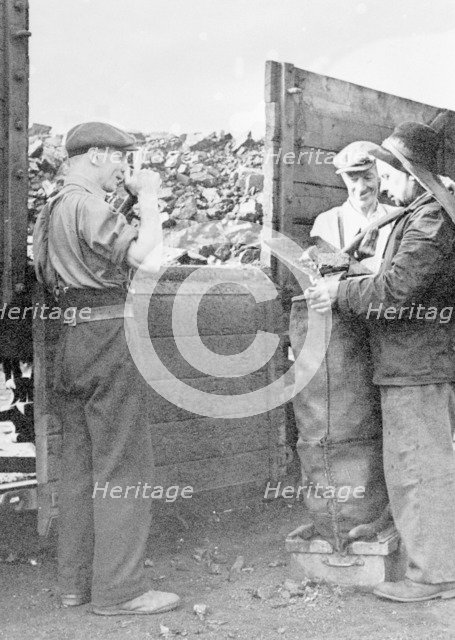 Charringtons' workers filling sacks of coal. Artist: Unknown