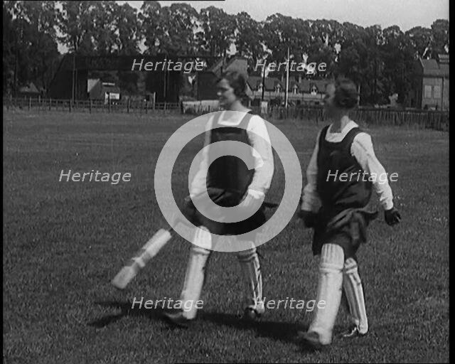 Two Female Civilians Wearing Gymslips and Batting Pads Holding Cricket Bats in a Playing Field, 1920 Creator: British Pathe Ltd.