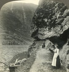 'Where the road creeps under the jutting cliffs by the waters of the Nerofjord, Norway', c1905. Creator: Unknown.