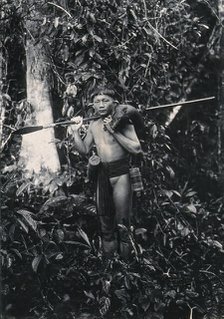 Sarawak: a Kenyah hunter with blowpipe and dead animal, c1900. Creator: Unknown.