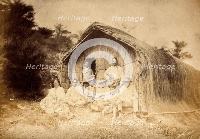 New Zealand: a group of Maori sitting in front of a traditional house, between 1800 and 1899. Creator: Unknown.