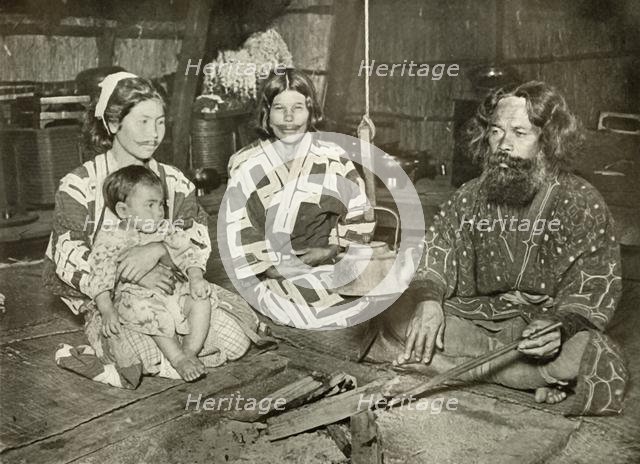 'Ainu Man and Women at Home', 1910. Creator: Herbert Ponting.