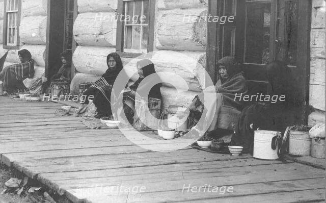 Indians sitting with backs to wall selling berries, between c1900 and c1930. Creator: Unknown.