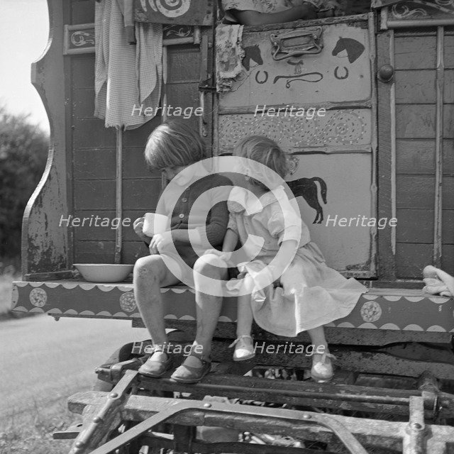 Children sitting on the steps of a gipsy caravan, Outwood, Surrey, 1963.
