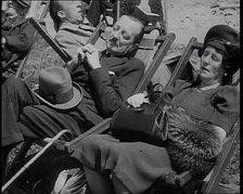 A British Couple Asleep in Deckchairs in the Sunshine in Hyde Park, the Man Has His Legs.., 1938. Creator: British Pathe Ltd.