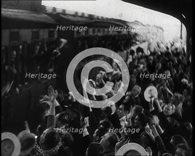 British Men Leaning Out of Railway Carriages and Saying Goodbye to People on a Crowded..., 1939. Creator: British Pathe Ltd.