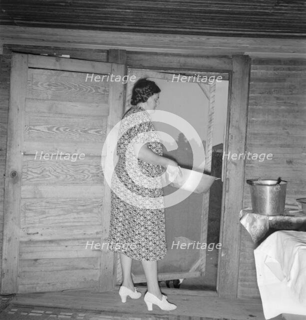 Tobacco sharecropper's wife disposing of dishwater..., Person County, North Carolina, 1939. Creator: Dorothea Lange.
