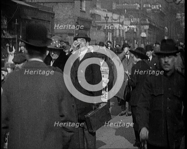 Men Wearing 'Pathe Gazette' Sandwich Boards Handing Out Pieces of Polaroid Film to Crowds..., 1921. Creator: British Pathe Ltd.