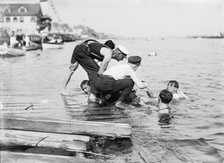 Untying Otto after 45 yd. swim - hands and feet tied, (1910?). Creator: Bain News Service.