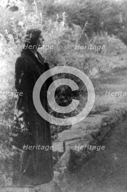 Frances Benjamin Johnston, full-length portrait, standing in garden, right profile, c1880 - 1950. Creator: Gertrude Kasebier.