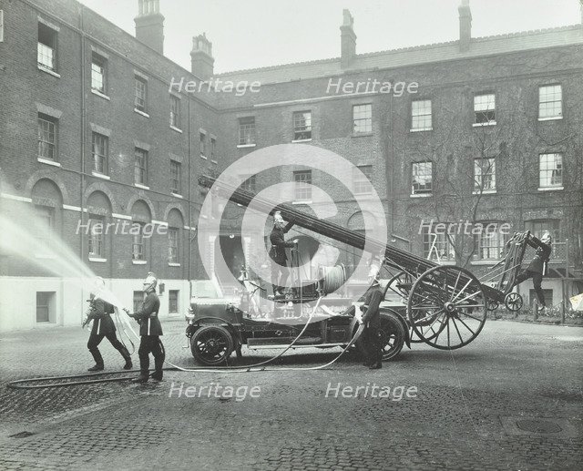 Fireman using a hose, London Fire Brigade Headquarters, London, 1910. Artist: Unknown.