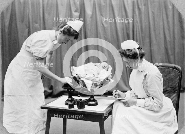 General Lying In Hospital, York Road, Lambeth: nurses weighing a baby, 1908. Creator: Unknown.