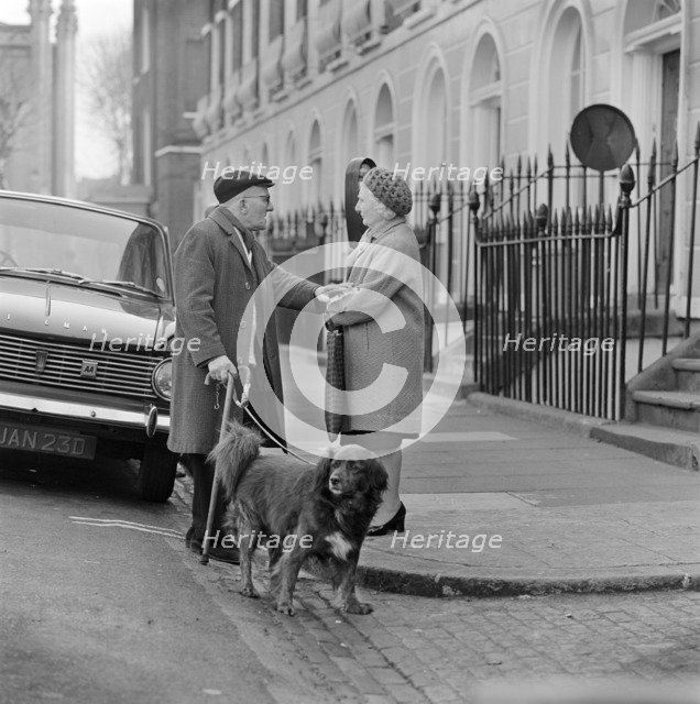An elderly man chats to an elderly woman on the pavement, London, c1946-c1959. Artist: John Gay