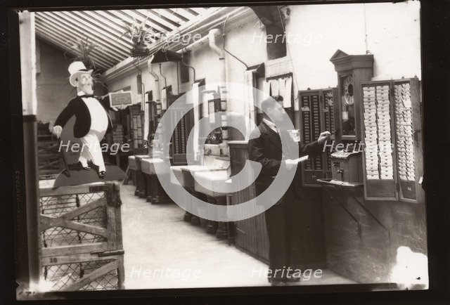 A man uses the clocking in machine, Rowntree factory, Yorkshire, 1929. Artist: Unknown